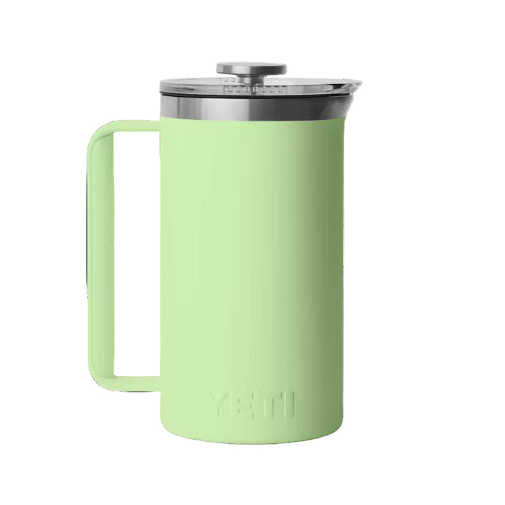 Light green coffee press with a silver lid on a black background